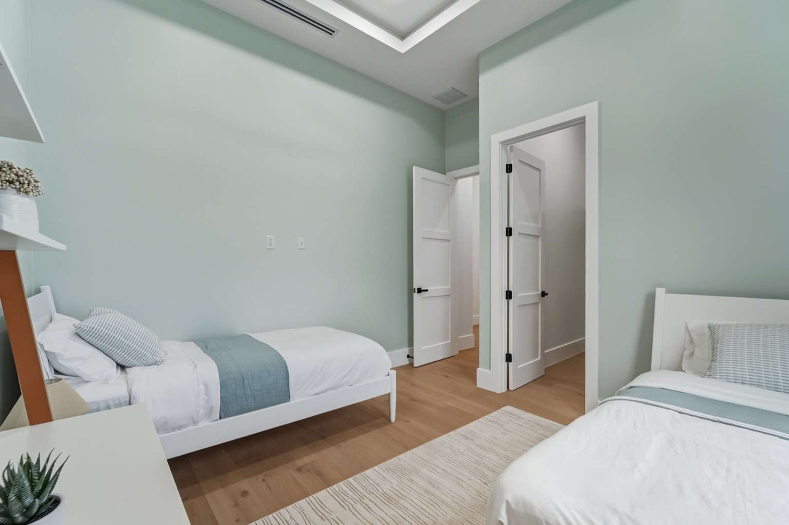 Modern coastal exterior home painted white with dark garage doors